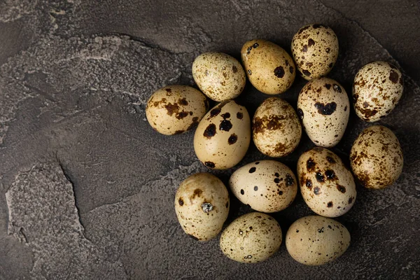 Quail eggs on black texture background. Whole and broken quail eggs. Natural products. Place for text. Fresh quail eggs. Protein. Calcium.