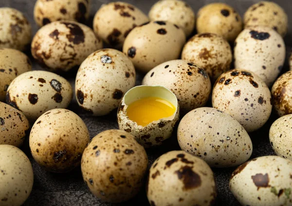Quail eggs on black texture background. Whole and broken quail eggs. Natural products. Place for text. Fresh quail eggs. Protein. Calcium.