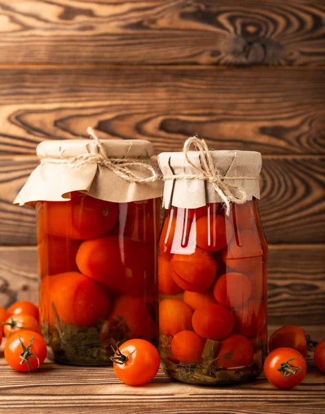 Pickled tomatoes in a jar on a brown wooden background. Food supplies. Healthy food. Harvesting. copy space. Place for text.