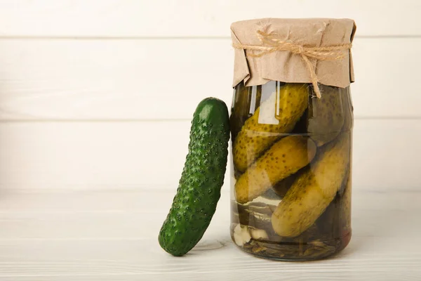 A jar of pickles. Canned cucumbers in a jar on a white table.Healthy food.Organic product.Vegetables collection. Pickled jars. Stocks for the winter. home preservation. pickles. Copy space