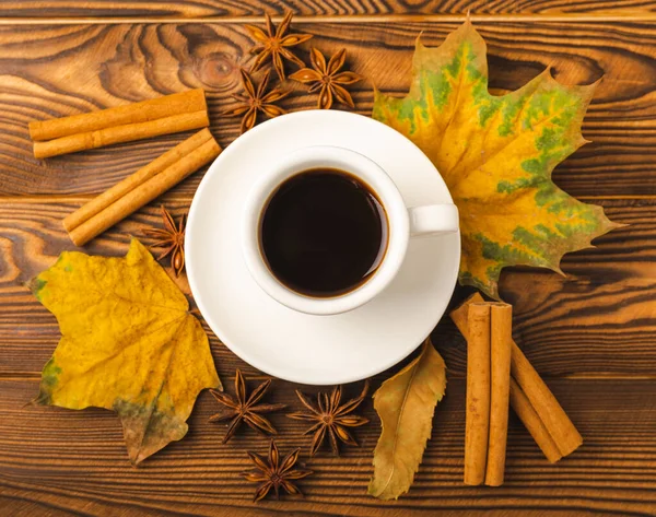 Autumn.Autumn leaves and a hot cup of coffee on a wooden table. Seasonal, morning coffee, Sunday relaxing and still life concept.Flat lay autumn composition.Autumn weekend mood concept.