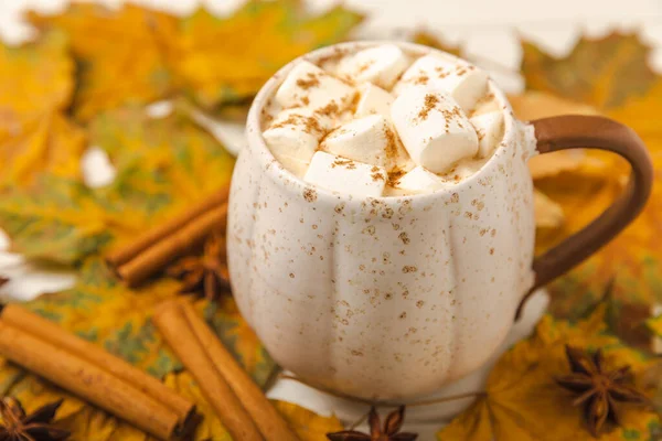 Autumn still life. Cocoa with marshmallows and maple leaves on a wooden table. Autumn season concept. Warming drink for relaxation, autumn weekend mood. Place for text. Place to copy. Flat lay