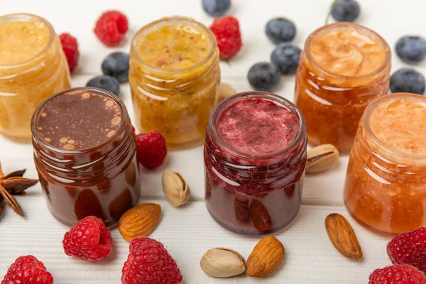 Jar of honey. Fruit honey with raspberries, blueberries, almonds and pistachios. Jams for health and beauty. Honey cream. Organic product of a vegetarian diet. Copy space.Copy space.
