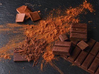 Koyu arkaplanı kakaolu çikolata parçaları.