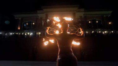 Güzel kız baştan çıkarıcı bir şekilde dans ediyor ve ateşle oynuyor.