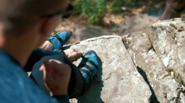 Kaya tırmanışçısı kayaya tırmanmadan önce özel kaya ayakkabıları düğmeler