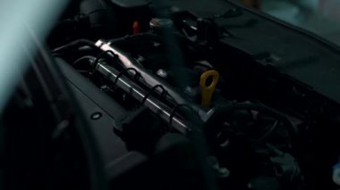 Motor kaputun altında, benzin istasyonunda, arka planda.
