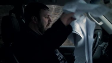 Office manager screams hysterically and hits the steering wheel of the car in the parking lot, scattering important documents in super slow motion.