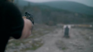 Adam tabancayla ateş ediyor, kendini korumayı öğreniyor, yavaş çekimde, yakın çekimde..