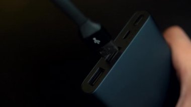 Telefonu şarj etmek için kullanılan kablo, lityum iyon pilli bir güç bankasının taşınabilir değişimine bağlanıyor..