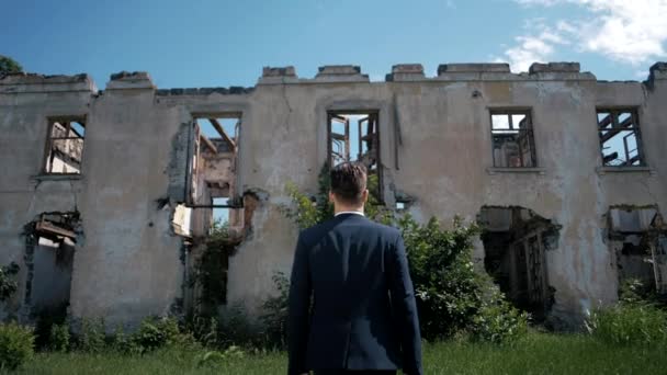 Joven Hombre Éxito Una Chaqueta Una Casa Arruinada Abandonada — Vídeo de stock