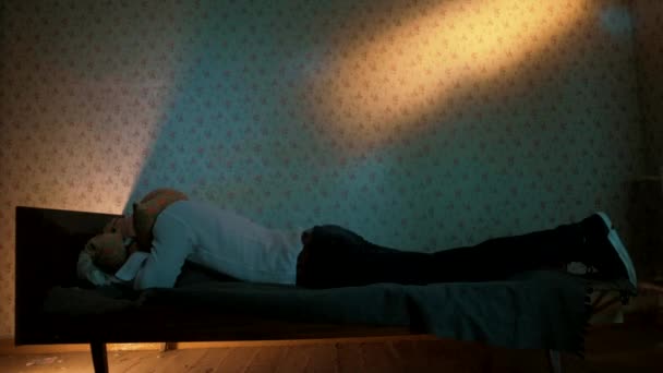 Чоловік Лежить Ліжку Старої Квартири Покриває Голову Подушкою — стокове відео