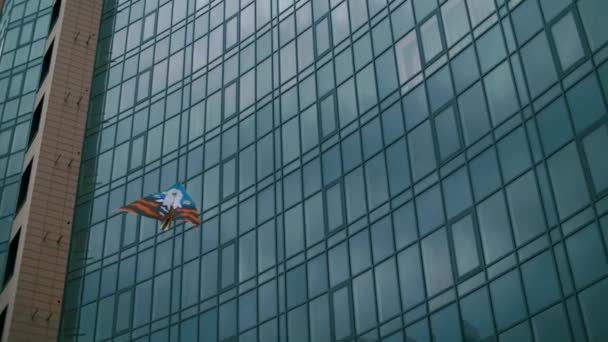 风筝在带有玻璃立面的大型摩天大楼的背景上飞舞 — 图库视频影像