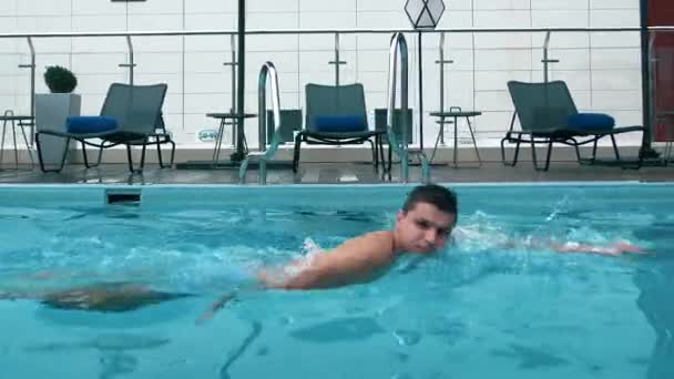 在酒店度假的游客正在夏天和蓝色的水一起爬到游泳池里游泳 — 图库视频影像