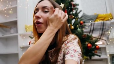 İnternette konuşan çekici bir kızın görüntüsü, elinde kamera, Noel gecesi video görüşmesi, ailesini tebrik eden genç bir kız..