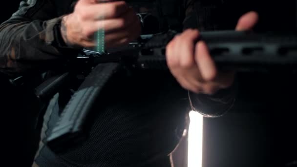 軍人は武器を戦闘位置に持ち込む 黒の背景 — ストック動画