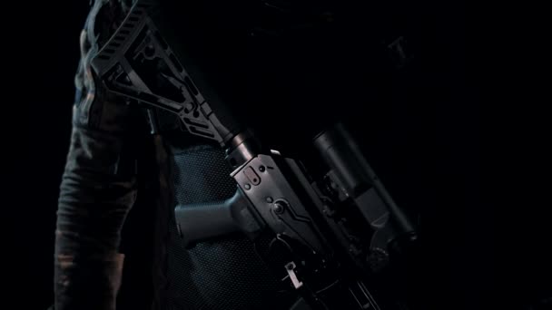 黒の背景にマルチカムの男は戦闘位置に彼の近代的な機関銃をスローします — ストック動画