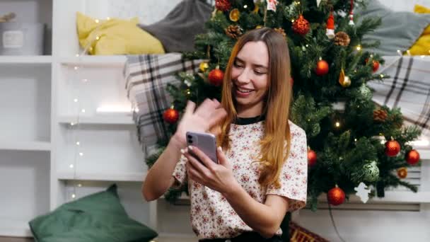 Schöne Mädchen Sitzt Silvesterabend Vor Dem Hintergrund Eines Weihnachtsbaums Und — Stockvideo