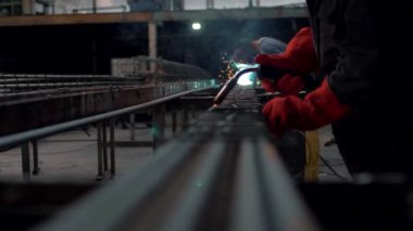 Metal atölyesindeki kaynakçı çelik parçaları pişiriyor. Yakın plan. Kıvılcım