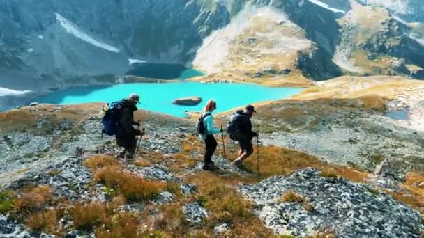 一群年轻的登山者在湖的背景下穿山越岭 — 图库视频影像