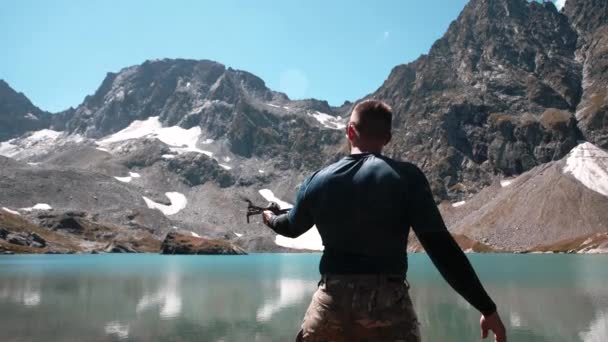 Mężczyzna Sportową Sylwetką Wystrzeliwuje Drona Rąk Pobliżu Górskiego Jeziora — Wideo stockowe