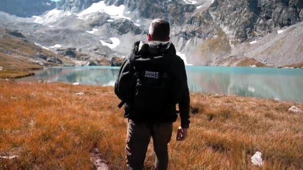 戴着太阳镜从融化的冰川上绕着高山湖游的人很可爱 — 图库视频影像