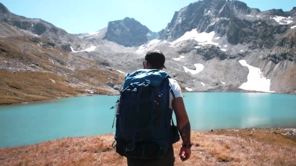 Молодий Альпініст Великим Пішохідним Рюкзаком Відправляється Гірське Озеро Влітку — стокове відео