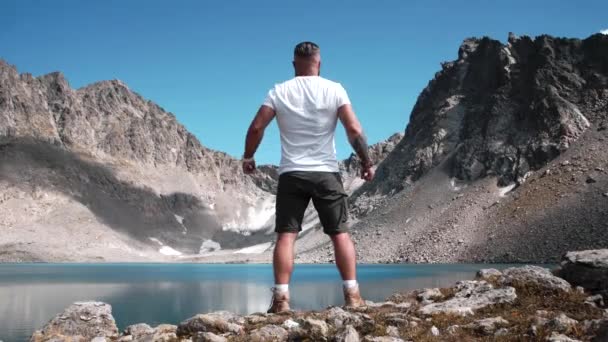 Чоловік Бородою Спортивним Тілом Стоїть Вершині Гори Біля Гірського Озера — стокове відео