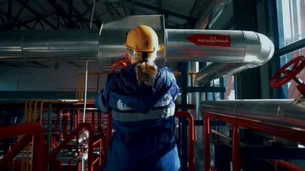 Kvinnlig Arbetare Fabrik Hjälm Och Uniform Roterar Stor Röd Ventil — Stockvideo