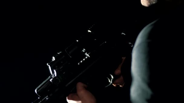 特殊部隊の兵士が黒い背景の戦闘位置にライフルを投げ込む — ストック動画
