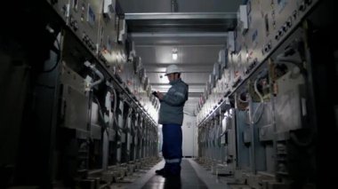 Elektrik santrali çalışanı, yüksek voltajlı santraldeki aygıtların performansını izliyor