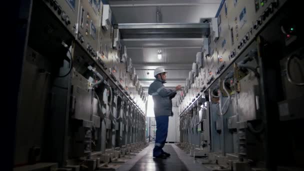 Μηχανικός Εργασίας Επιθεωρεί Τον Πίνακα Διανομής Ηλεκτρικού Ρεύματος Μια Μονάδα — Αρχείο Βίντεο