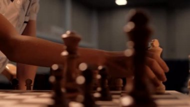 Çocukların elleri satranç tahtasındaki satranç taşlarını oynatıyor. Yakın plan. 