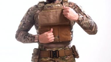 Askeri teçhizat uzmanı zırhlı taşıyıcısını çıkartıyor. Beyaz arka plan. İzole edilmiş