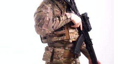 Tam teçhizatlı bir askeri uzman elinde bir saldırı tüfeğiyle bölgede devriye geziyor. Beyaz arka plan. İzole edilmiş