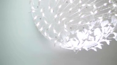 Beyaz tavanlı modern seramik avize. Güzel asılı detaylar ışık ve gölgede parıldıyor.