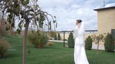 Güzel, doğal bir yerde şık bir gelinlik içinde çekici bir gelin. 