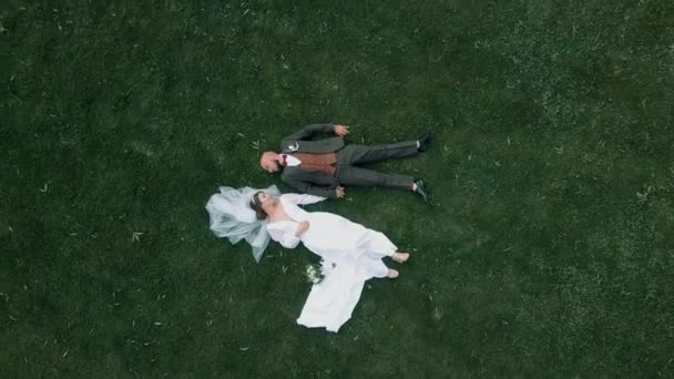 Красивая Молодая Невеста Жених Лежат Траве Держатся Руки Удивительном Природном — стоковое видео