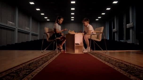 年齢の子供たちはテーブルに座ってチェスをする — ストック動画