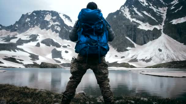 游客举手并肩站在山顶上 欣赏高山湖景 高山和草地 — 图库视频影像
