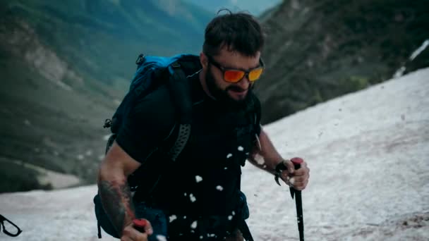 带着时髦眼镜带着胡子的攀登者带着攀登设备在山上升起了一座冰川 慢动作 — 图库视频影像