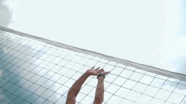 Erkekler plaj voleybolu maçında voleybol oynuyorlar.