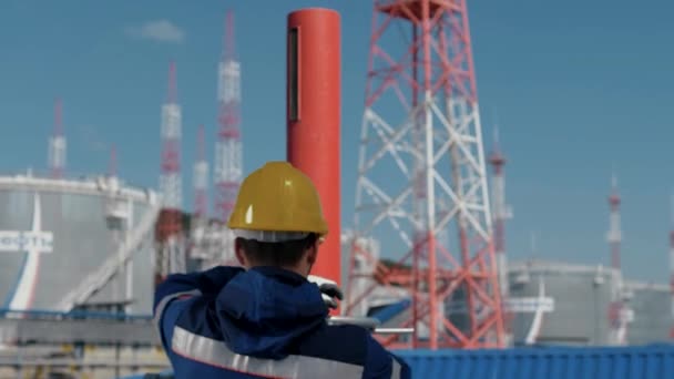 石油工人在输油管道上旋转一个巨大的阀门 — 图库视频影像