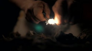Eski bir adam bir mağarada ateş yakıyor. Yavaş çekim