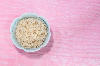 Pembe arka planda izole edilmiş pirinç kahverengisi yakın plan, üst görünüm, yiyecek ve içecek konsepti.