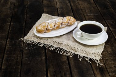 Ahşap masadaki kahve ve çörek yakın plan, üst manzara, kahvaltı ve içecek konsepti..