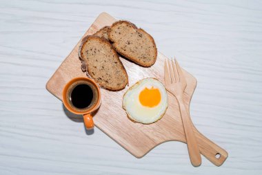 Kesme tahtasındaki kızarmış yumurtalı ekmek dilimi beyaz arka planda izole edilmiş espresso kahvesi yakın plan, üst manzara, kahvaltı ve içecek konsepti..