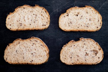 Ekmek dilimlenmiş ekmek deseni siyah ahşap arka planda izole edilmiş, kırsal kabuklu üst görünüm, yiyecek ve içecek konsepti.