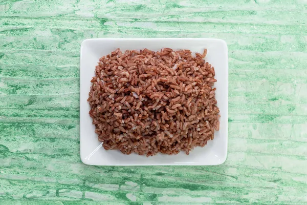 Pirinç kırmızısı yeşil arka planda izole edilmiş. Yakın plan, üst manzara, Asya yemekleri ve içecek konsepti..