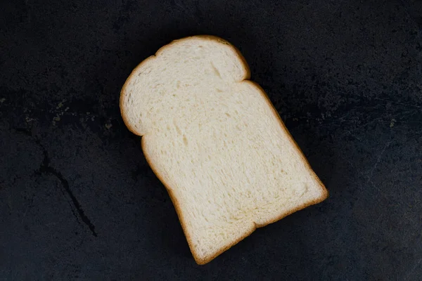 Wit Brood Plak Geïsoleerd Zwarte Steen Achtergrond Close Bovenaanzicht Kopieerruimte — Stockfoto